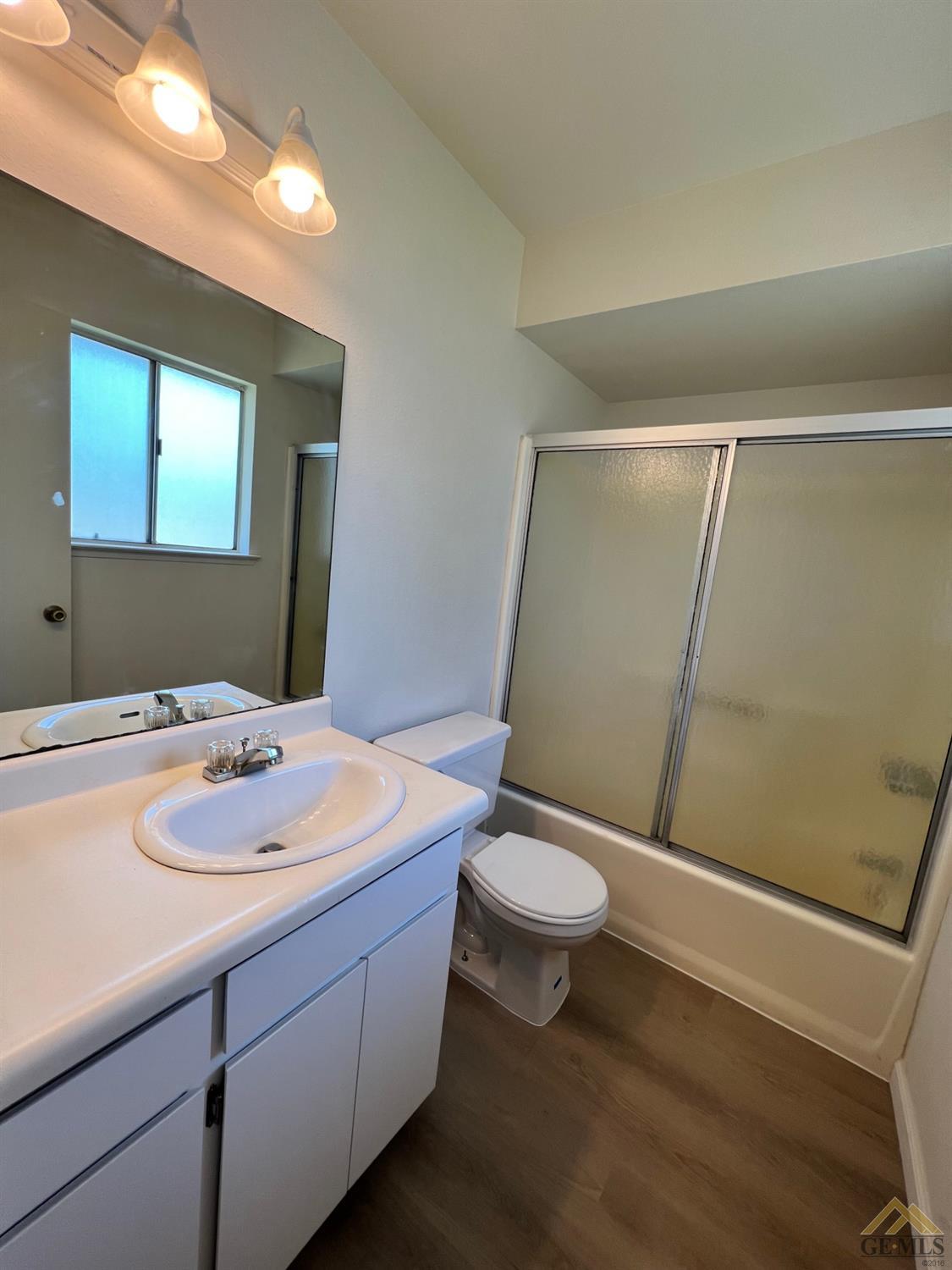 Undisclosed Address Wasco, CA 93280 - Photo 13 of 17 a bathroom with a sink a toilet a mirror and vanity