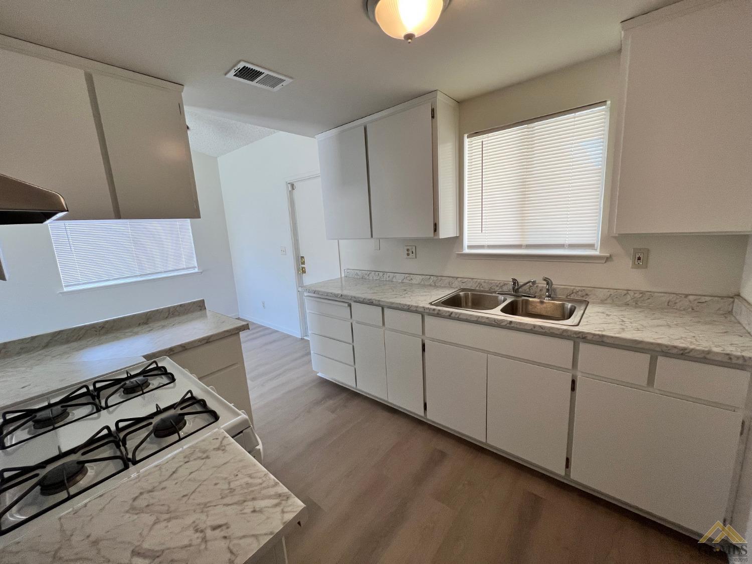Undisclosed Address Wasco, CA 93280 - Photo 4 of 17 a kitchen with sink stove and cabinets