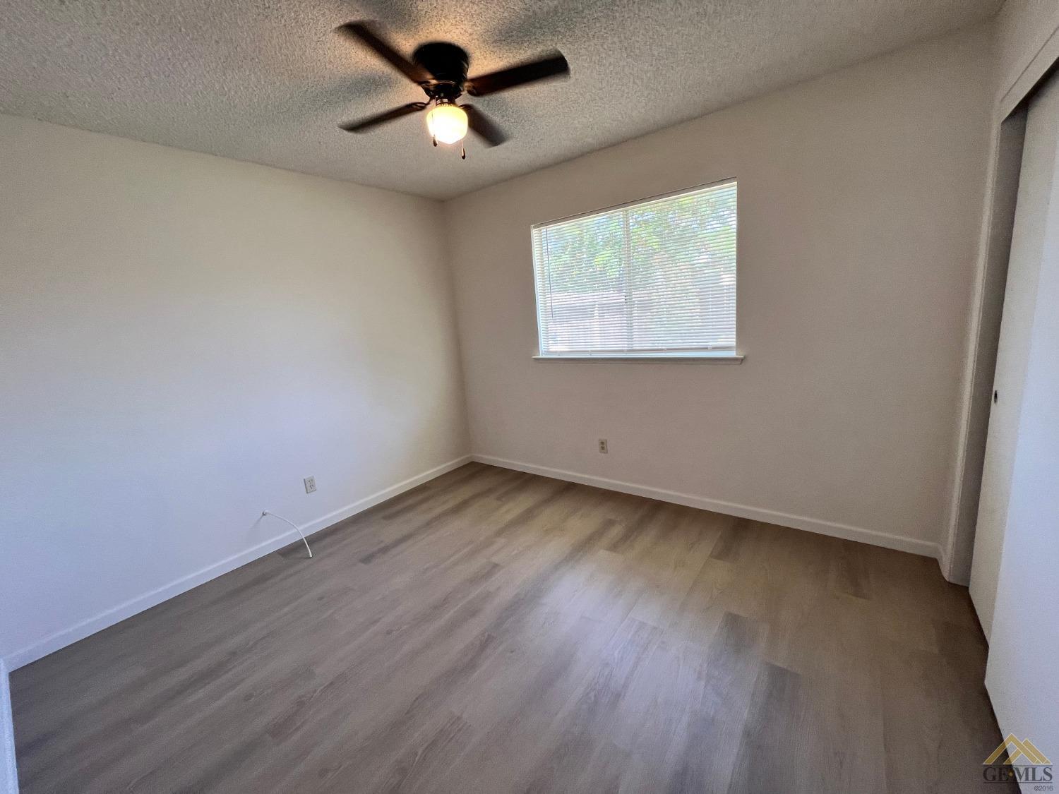 Undisclosed Address Wasco, CA 93280 - Photo 10 of 17 an empty room with a window and a ceiling fan