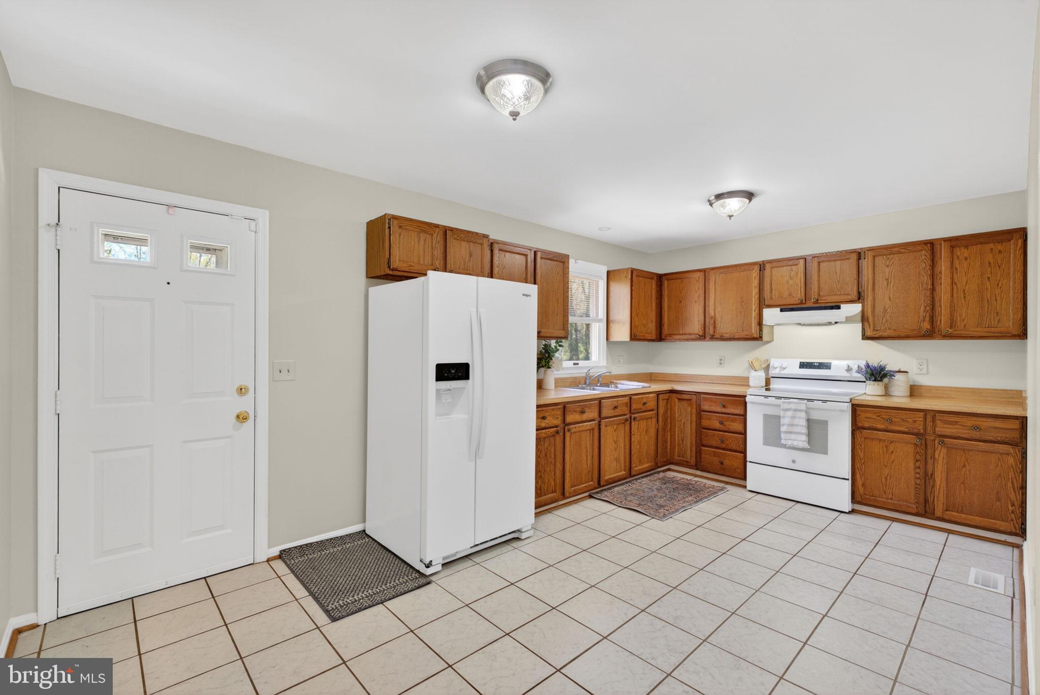 9283 Springs Road Warrenton, VA 20186 - Photo 9 of 18 a kitchen with a refrigerator sink and cabinets