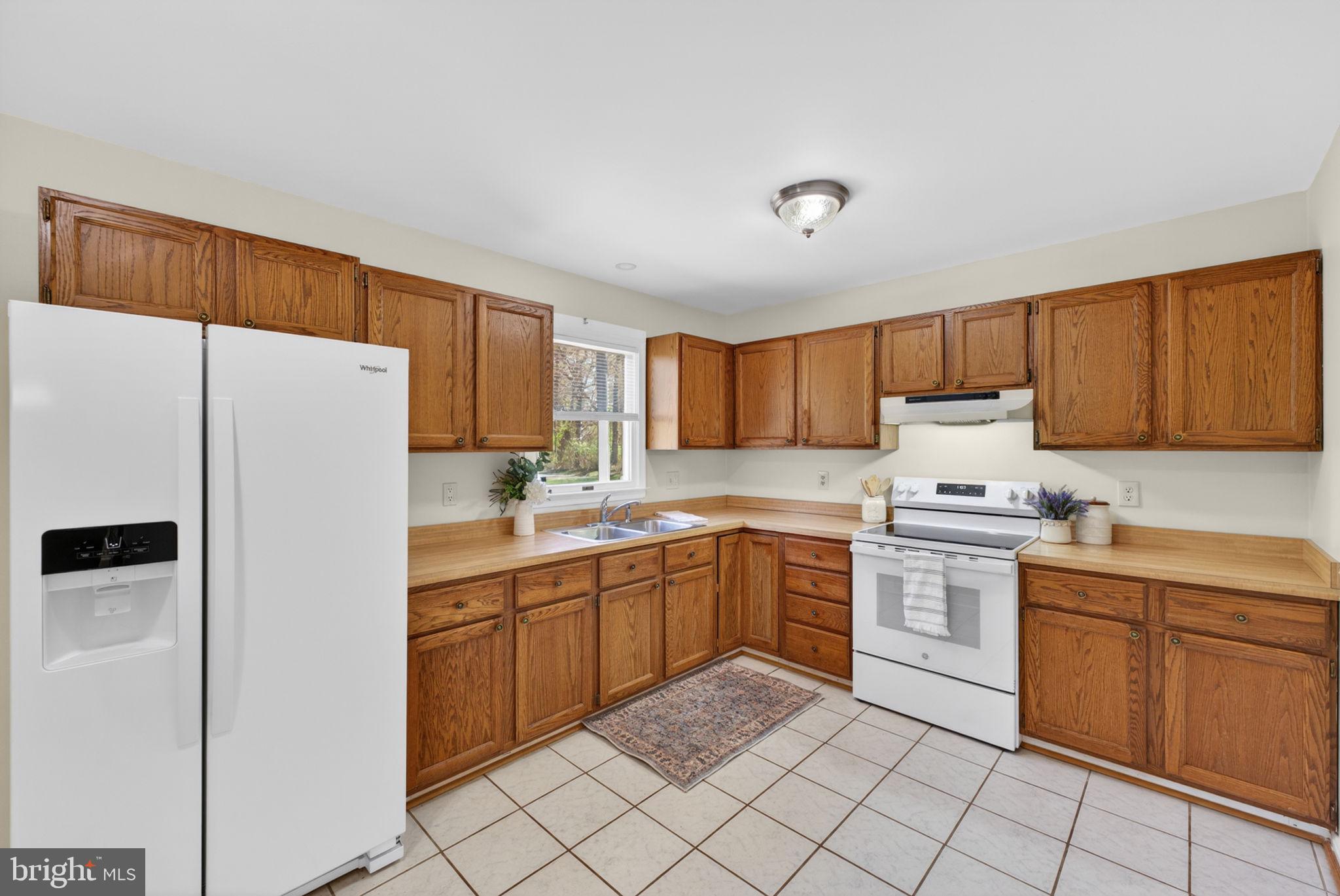 9283 Springs Road Warrenton, VA 20186 - Photo 10 of 18 a kitchen with white cabinets and white appliances