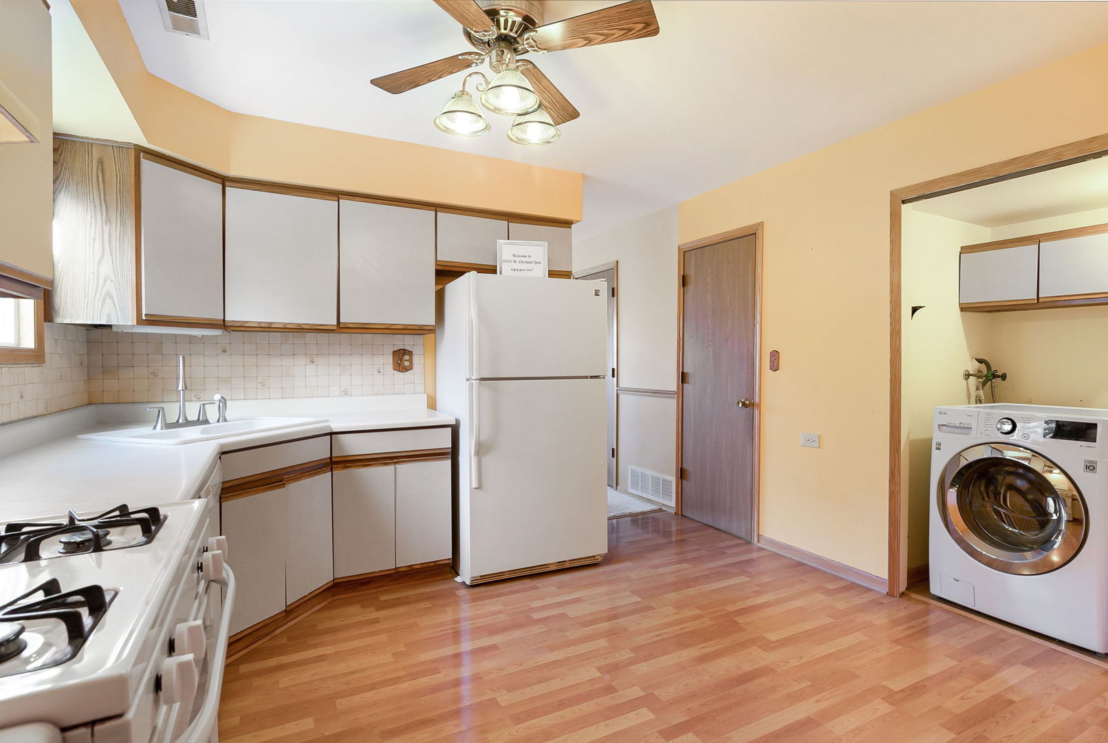 17475 Chestnut Lane Gurnee, IL 60031 - Photo 6 of 17 a kitchen with a refrigerator a stove top oven a sink and cabinets
