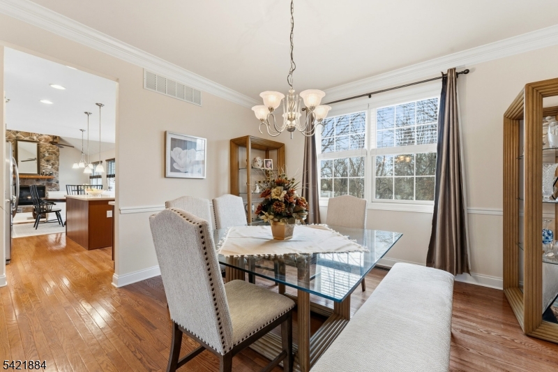 26 Rouser Way Hillsborough, NJ 08844 - Photo 10 of 49 a dining room with wooden floor a chandelier a wooden table and chairs