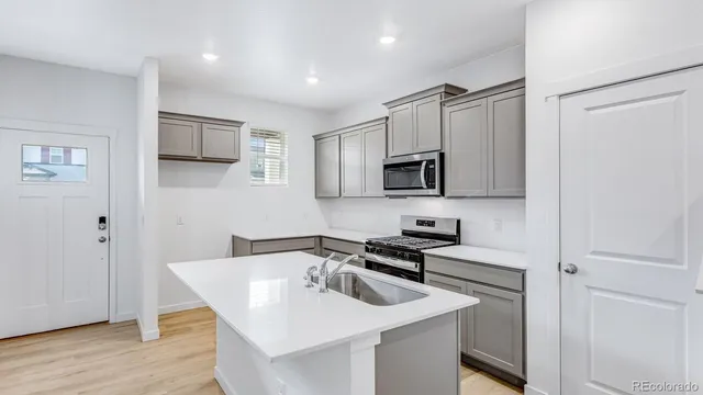 a kitchen with sink a microwave a stove and refrigerator