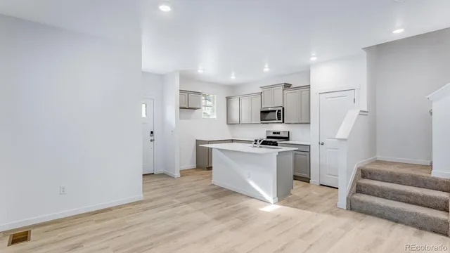 a kitchen with granite countertop a sink cabinets and wooden floor