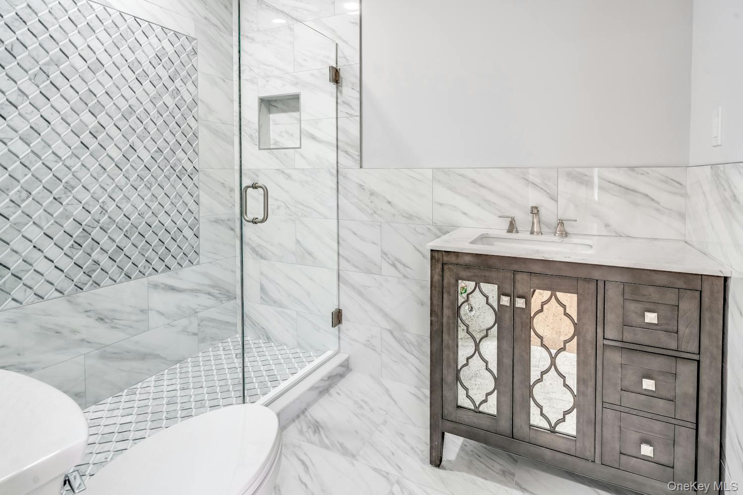 539 Split Rock Road Syosset, NY 11791 - Photo 24 of 40 Full bath with wainscoting, a sink, toilet, tile walls, and a shower stall