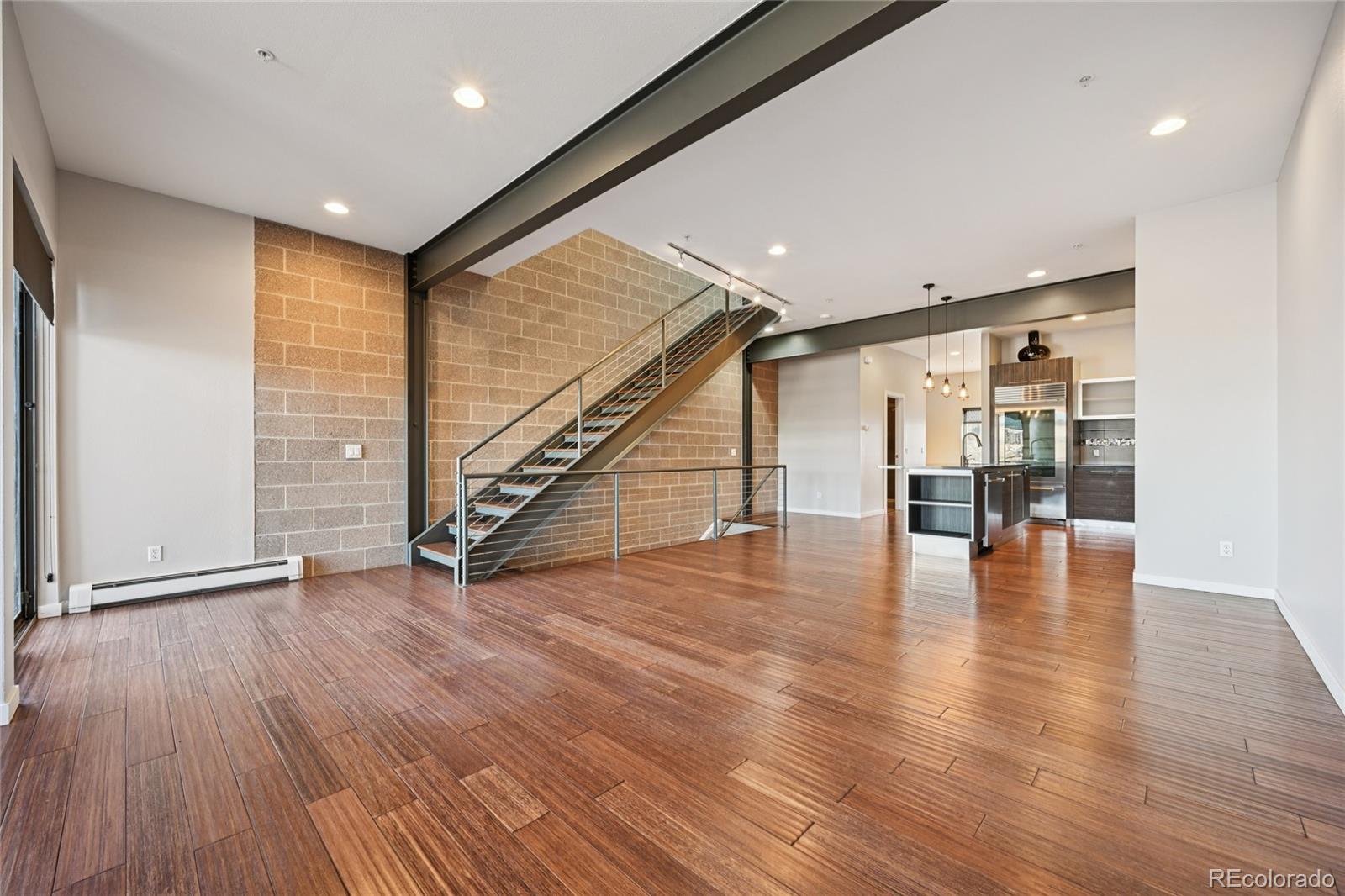 11562 Colony Row Broomfield, CO 80021 - Photo 19 of 48 a view of an empty room with wooden floor and stairs