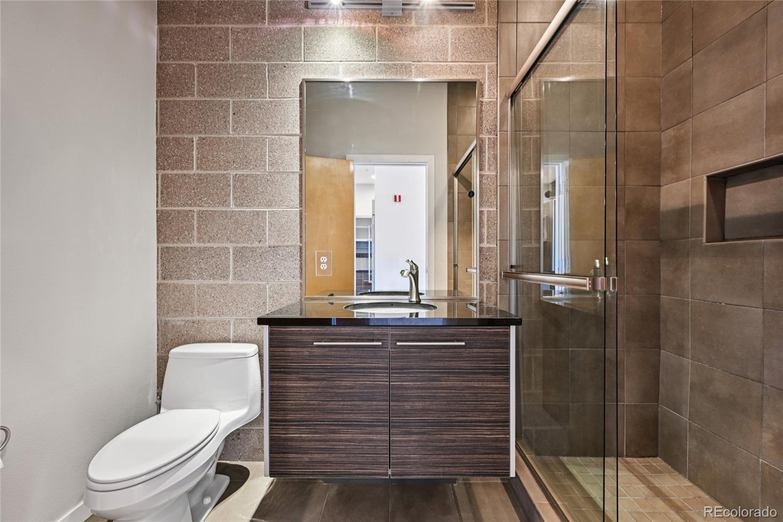 11562 Colony Row Broomfield, CO 80021 - Photo 26 of 48 a bathroom with a granite countertop toilet a sink and mirror