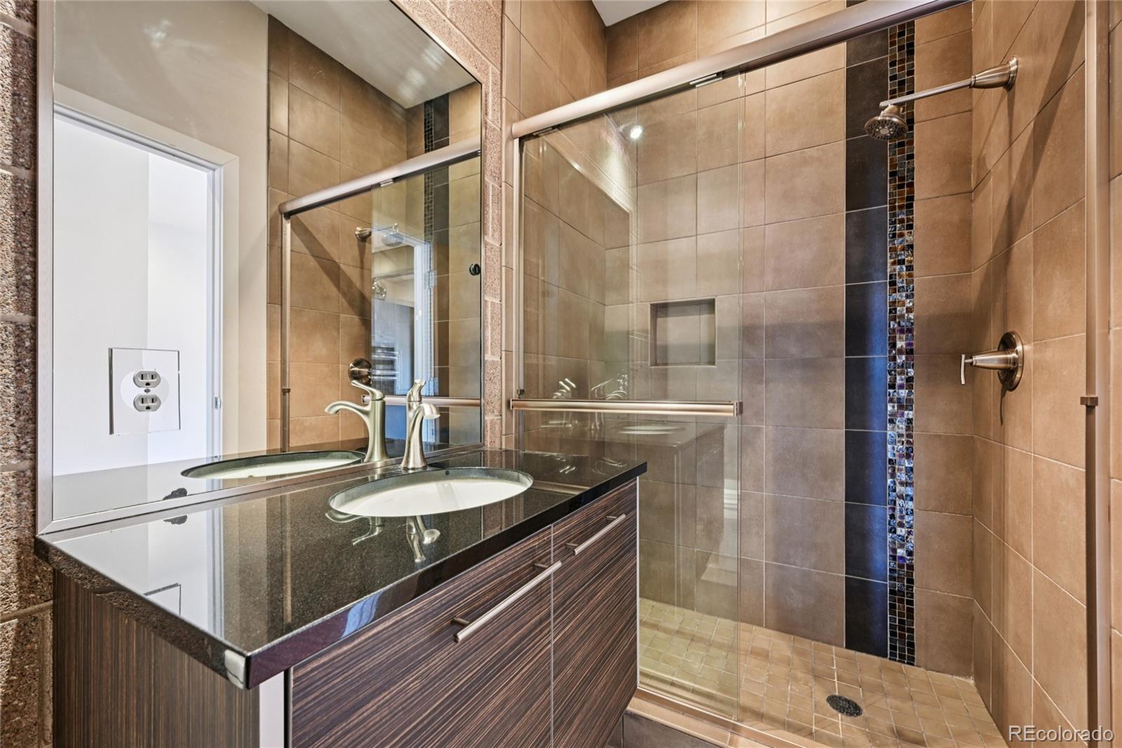 11562 Colony Row Broomfield, CO 80021 - Photo 27 of 48 a bathroom with a granite countertop sink a mirror and shower