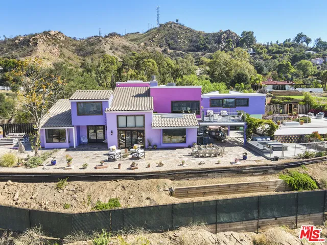 an aerial view of a house with a mountain