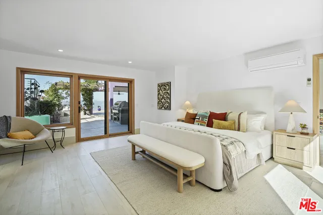 a bedroom with a bed and a large window