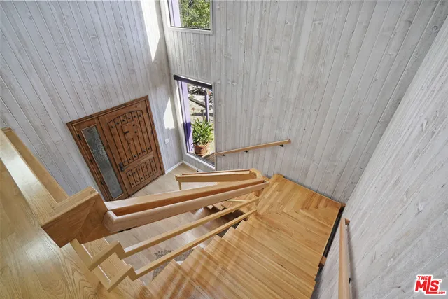 a view of a patio with couches table and chairs under an umbrella with potted plants