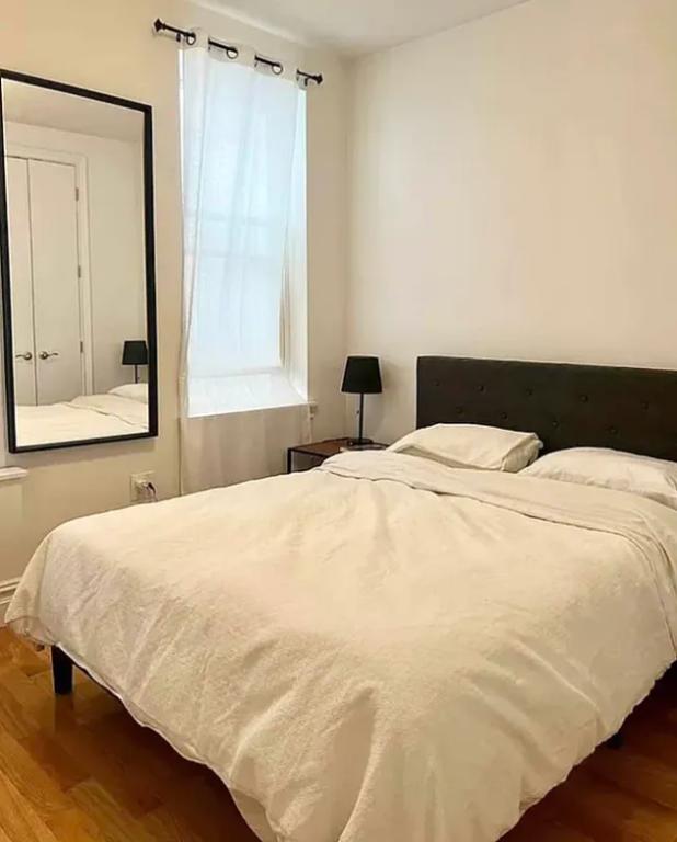 886 10th Avenue, Unit 5B Manhattan, NY 10019 - Photo 2 of 6 a large white bed in a white room