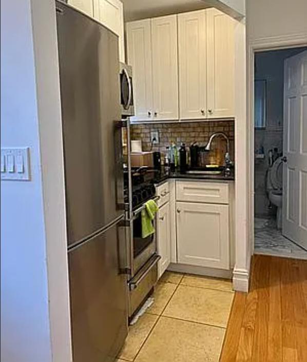 886 10th Avenue, Unit 5B Manhattan, NY 10019 - Photo 5 of 6 a kitchen with stainless steel appliances a refrigerator sink and cabinets