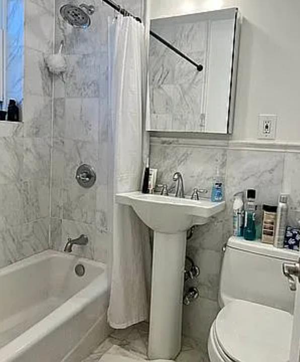 886 10th Avenue, Unit 5B Manhattan, NY 10019 - Photo 6 of 6 a bathroom with a sink a mirror a toilet and bathtub