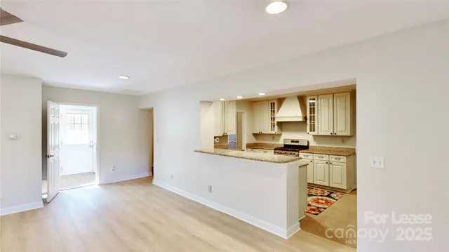 a kitchen with stainless steel appliances granite countertop a stove a sink and a refrigerator with wooden floor