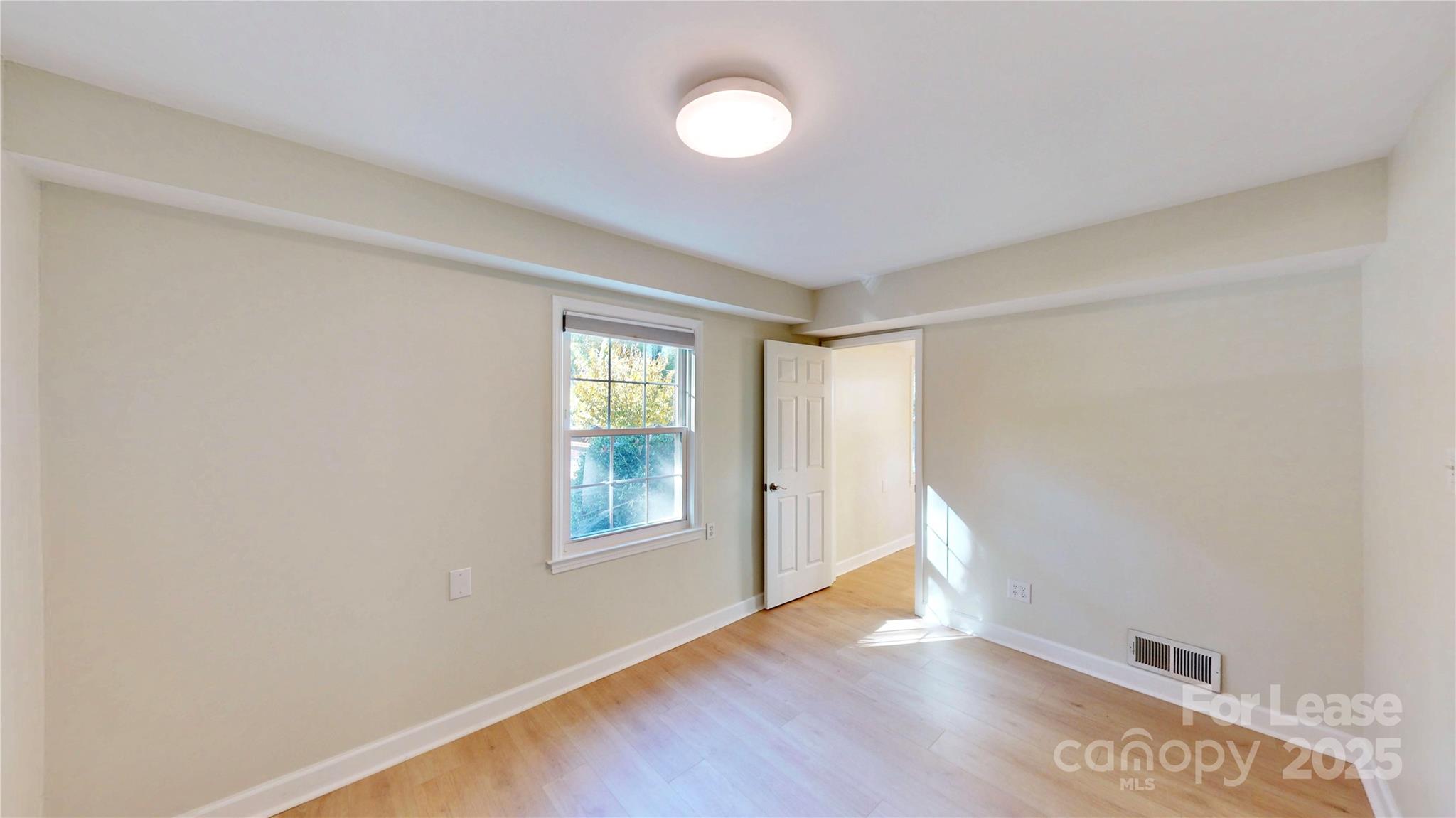 2844 Goneaway Road Charlotte, NC 28210 - Photo 37 of 41 a view of an empty room with window and wooden floor