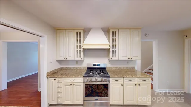 a kitchen with granite countertop white cabinets and appliances
