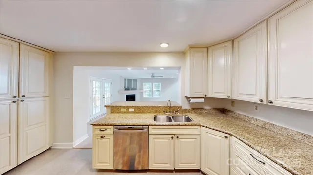 a kitchen with stainless steel appliances granite countertop a sink a stove and white cabinets