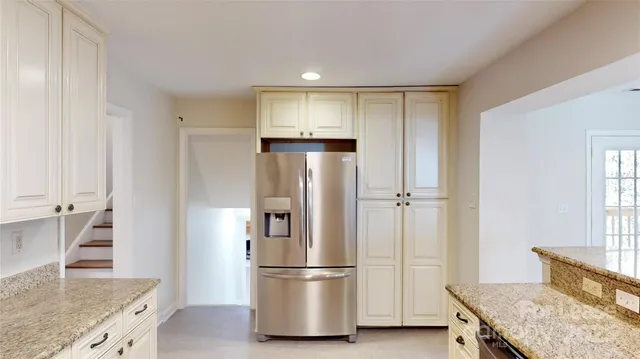 a kitchen with stainless steel appliances granite countertop a refrigerator and a stove