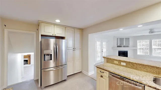 a kitchen with stainless steel appliances granite countertop a refrigerator and a stove top oven