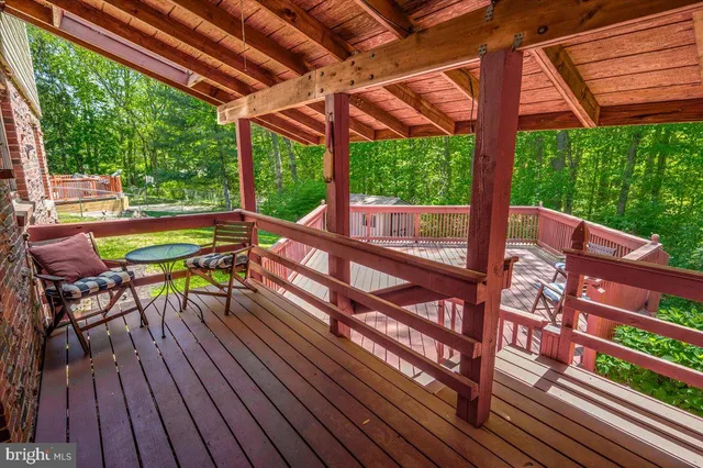 a view of a patio with table and chairs under an umbrella with wooden floor