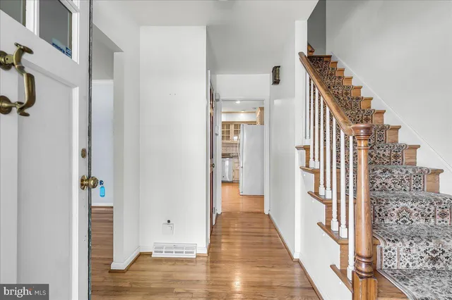 a view of a hallway with wooden floor and staircase