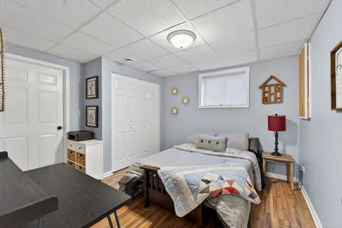 a bedroom with a bed and wooden floor