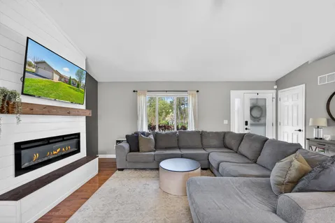 a living room with furniture a fireplace and a flat screen tv