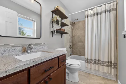 a bathroom with a granite countertop sink toilet and shower