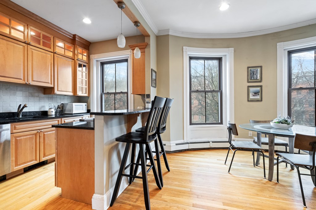 32 Union Park, Unit 2 Boston, MA 02118 - Photo 8 of 19 a kitchen with stainless steel appliances granite countertop wooden floor dining table and chairs