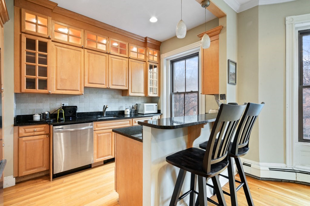 32 Union Park, Unit 2 Boston, MA 02118 - Photo 9 of 19 a kitchen with a table chairs in it and wooden floors