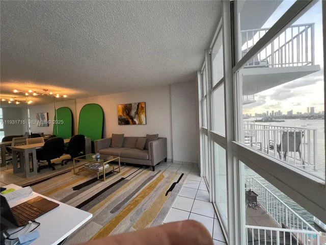 a living room with furniture a large window and a rug