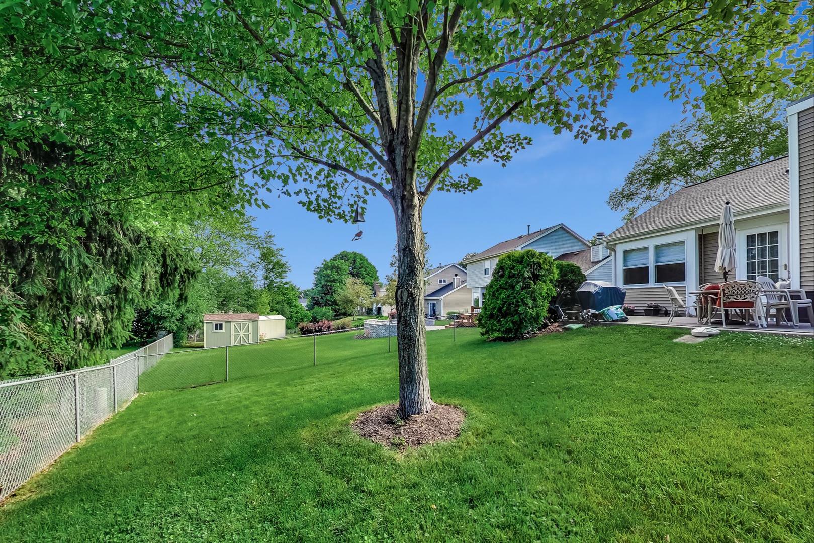 N440 Kimball Road Winfield, IL 60190 - Photo 18 of 21 a backyard of a house with table and chairs plants and large tree