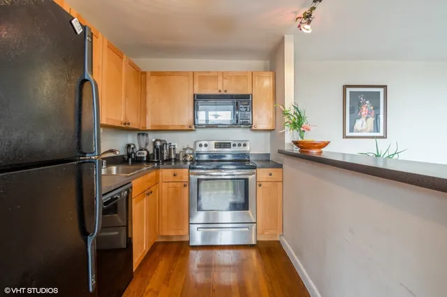 a kitchen with granite countertop stainless steel appliances a counter top space and a window
