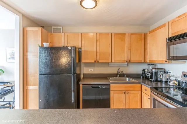 a kitchen with a refrigerator a sink a stove and cabinets