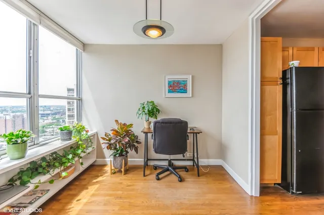 a view of a workspace with furniture and a window