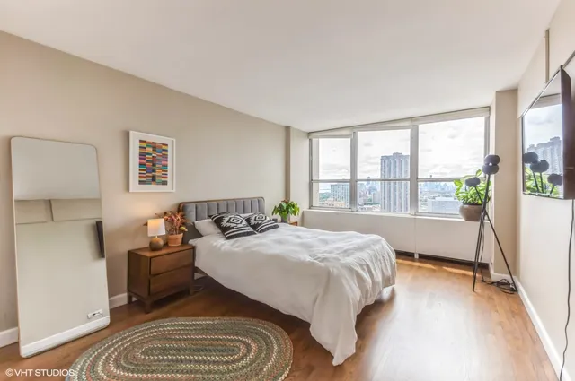 a bedroom with a bed and a large window