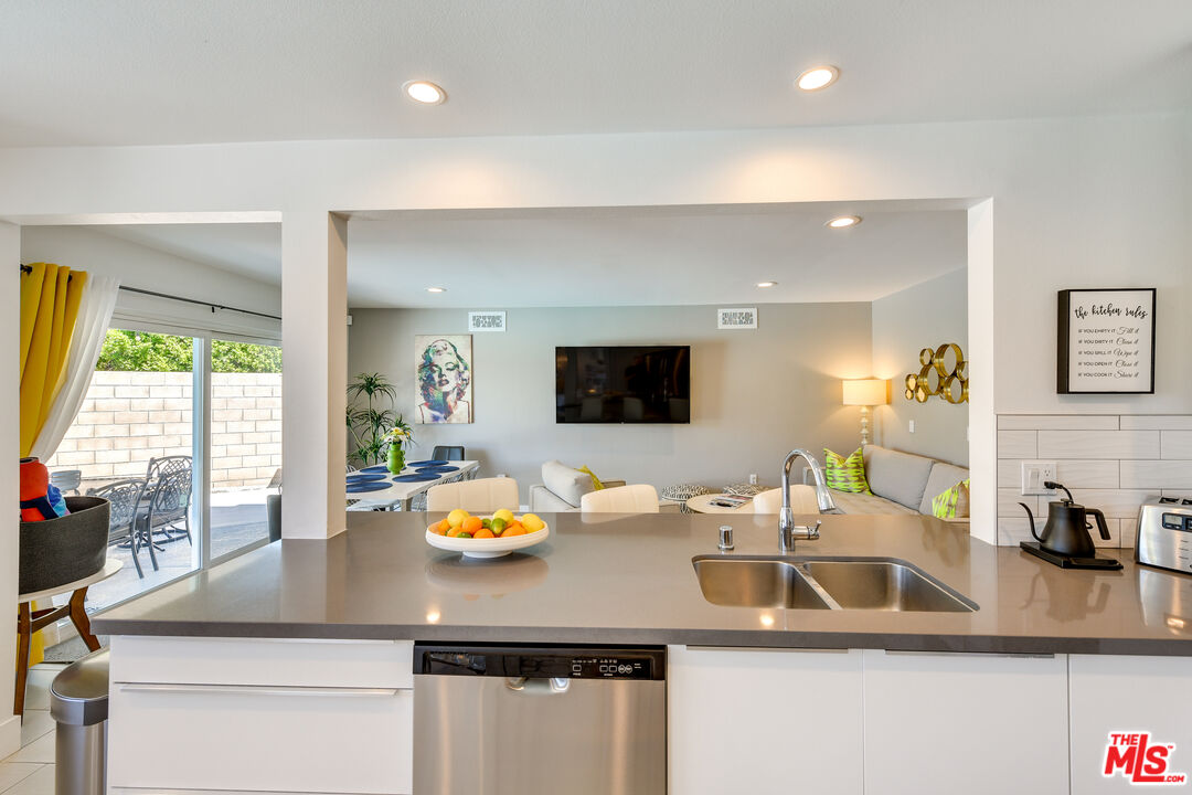 2146 North Blando Road Palm Springs, CA 92262 - Photo 9 of 31 a kitchen with a sink a counter space and living room