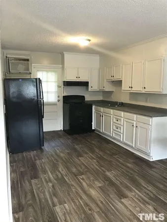 a kitchen with stainless steel appliances granite countertop a refrigerator a stove a sink and white cabinets