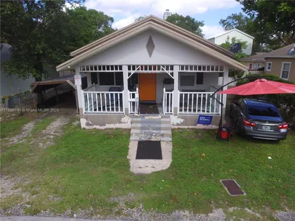 a front view of house with garden and trees