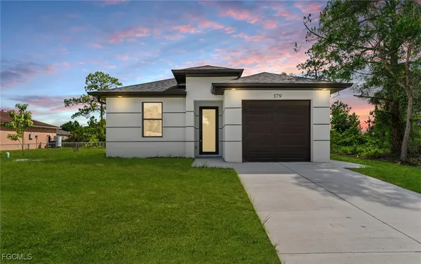 a front view of a house with a yard and garage