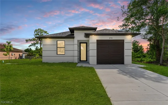 a front view of a house with a yard and garage