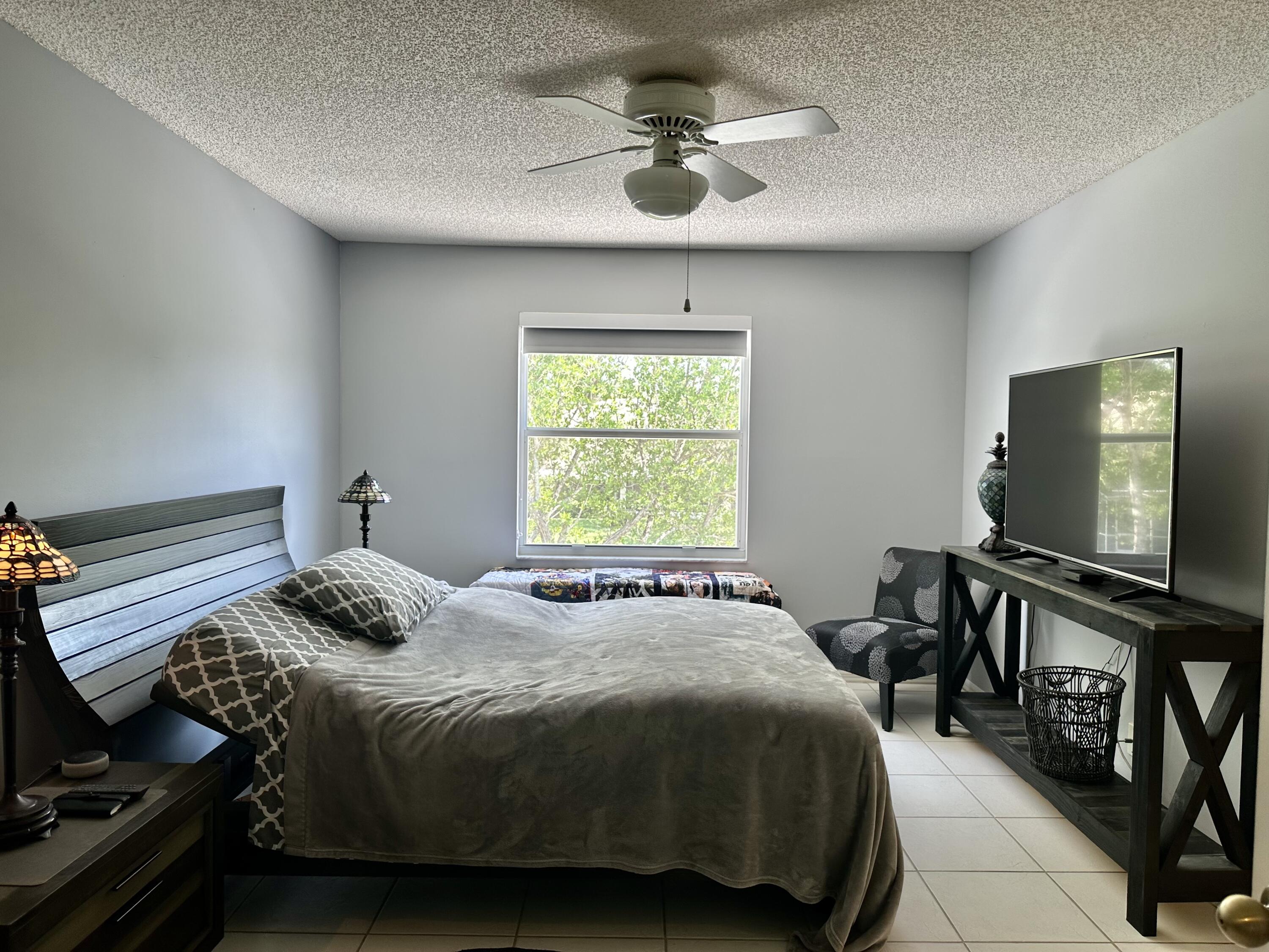 188 Timberwalk Trail Jupiter, FL 33458 - Photo 5 of 6 a bedroom with a bed and a flat screen tv