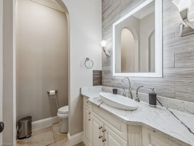 a bathroom with a granite countertop sink mirror and toilet