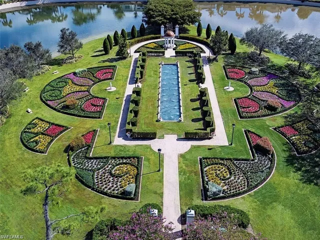a view of a swimming pool with a yard and potted plants