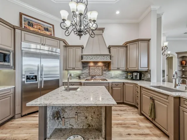 a kitchen with cabinets wooden floor dining table and stainless steel appliances