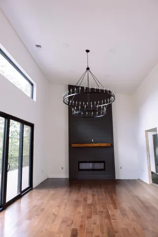a view of a room that has wooden floor and a window