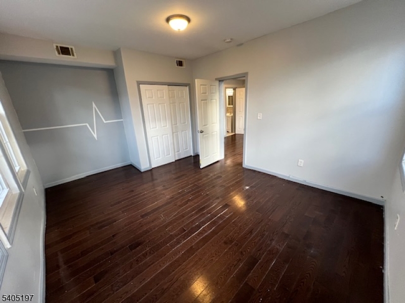 142 Sunset Avenue, Unit 1 Newark, NJ 07106 - Photo 5 of 10 an empty room with wooden floor and windows