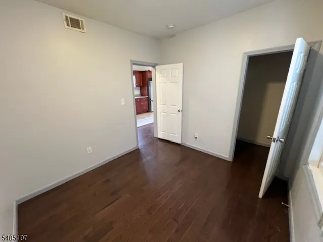 an empty room with wooden floor and entrance